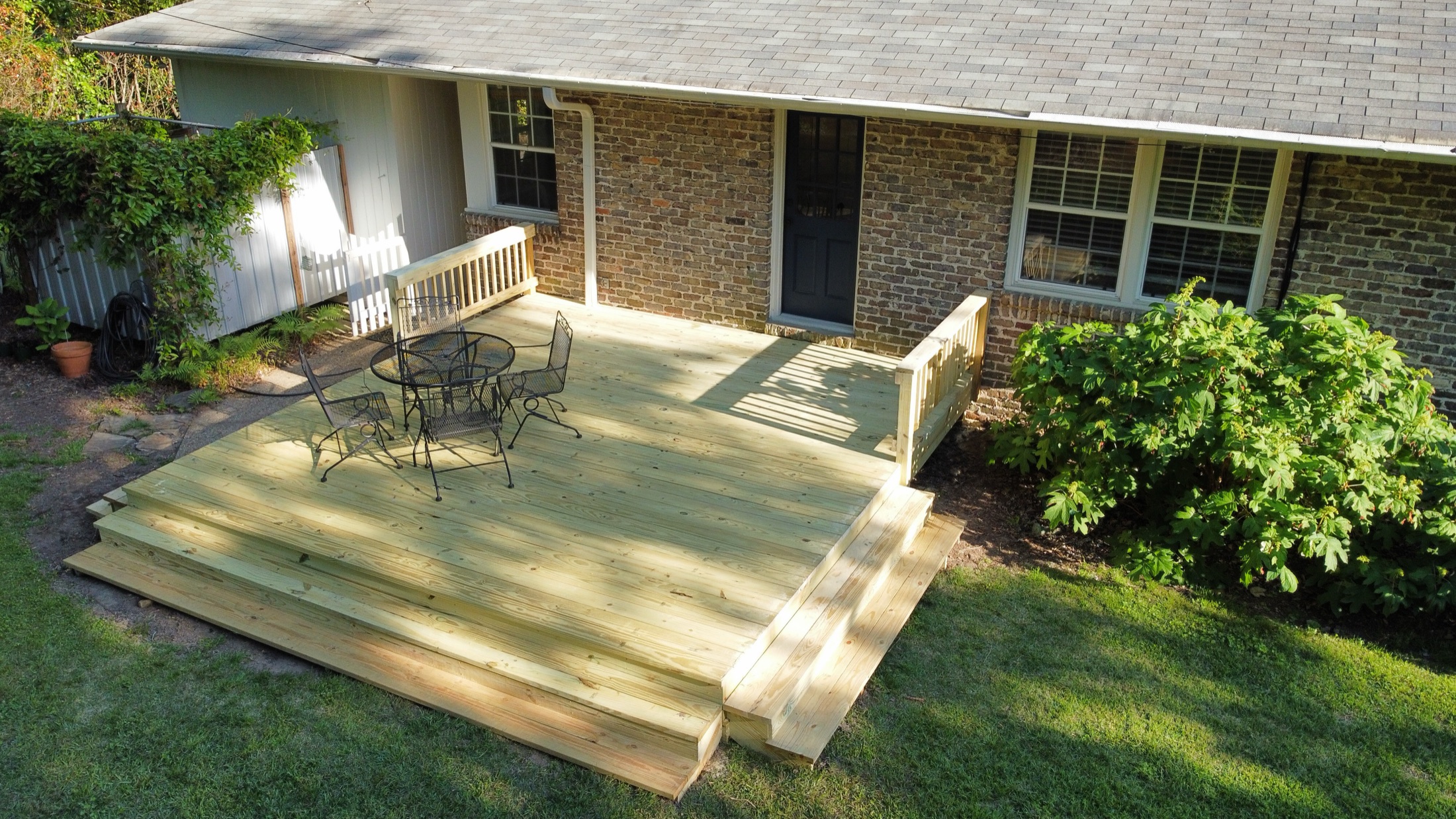 Deck and covered porch on a brick home built by Redbone Woodworks