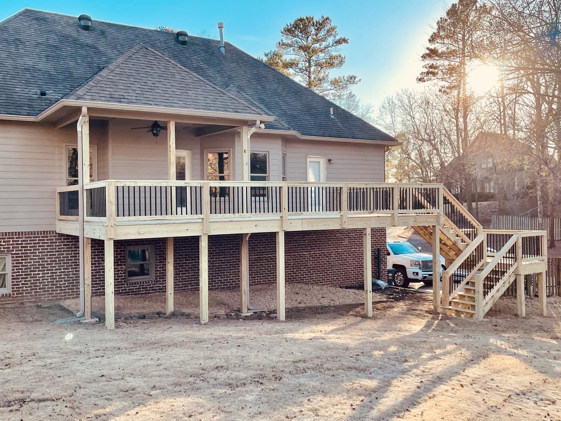 Deck and covered porch on a brick home built by Redbone Woodworks