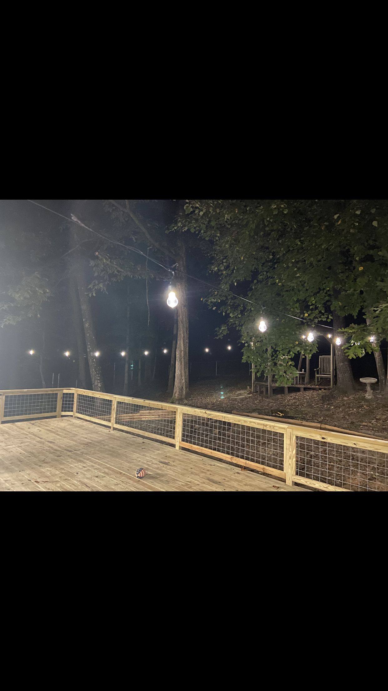 Deck at night with string lights built by Redbone Woodworks