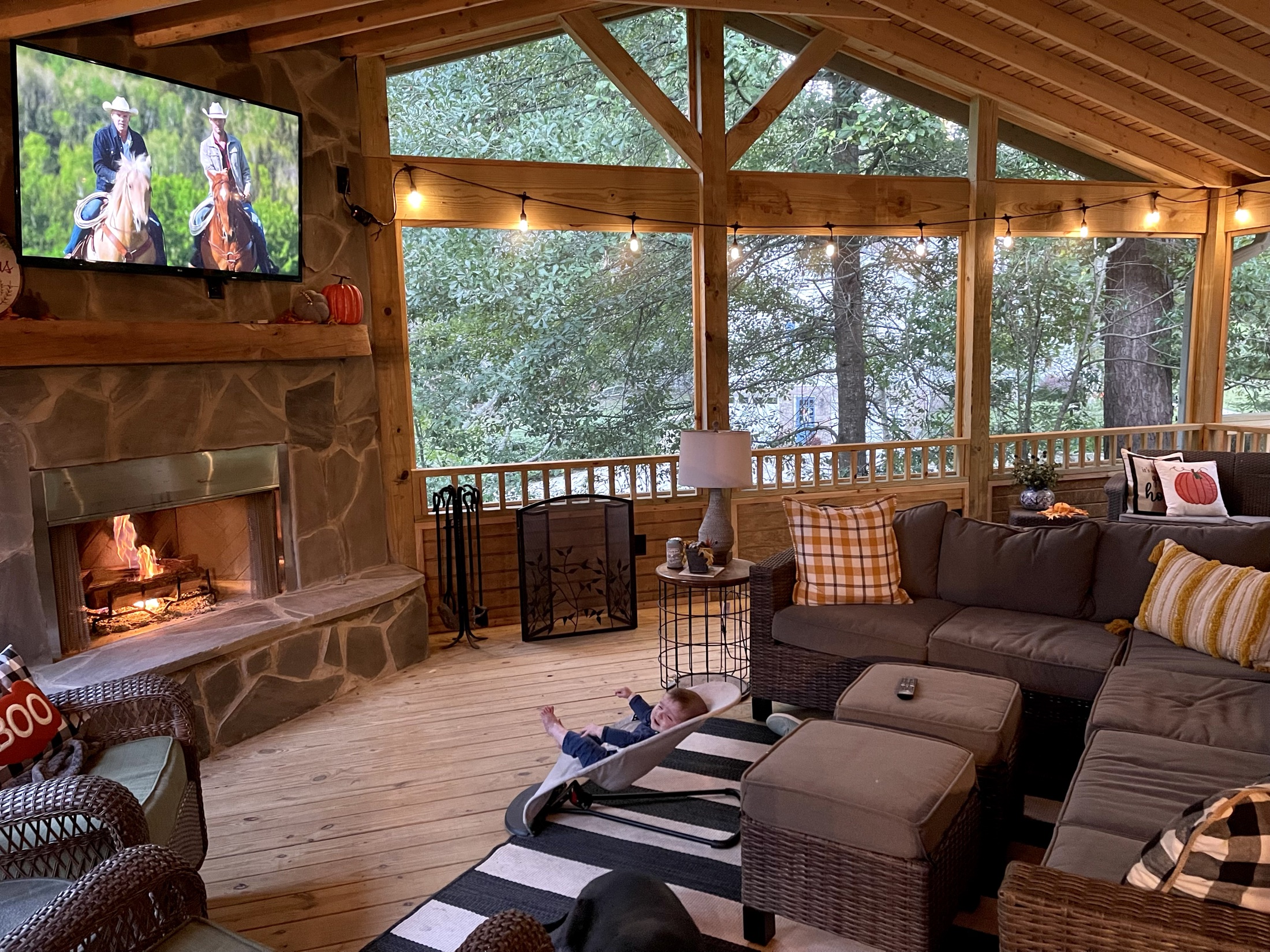 Screened porch with fireplace at evening built by Redbone Woodworks