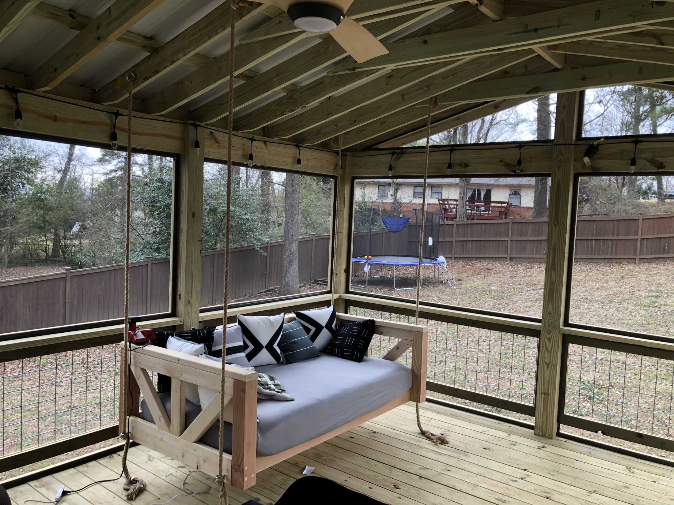 Screened porch hanging daybed swing interior built by Redbone Woodworks